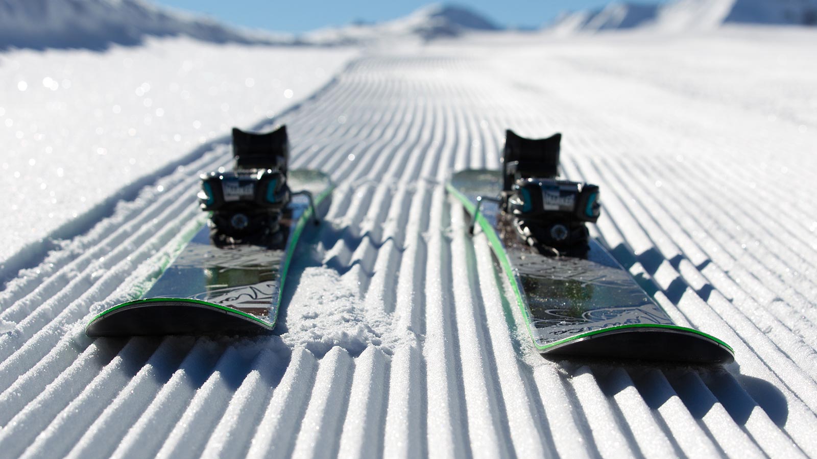 Snowboard on snow near mountain lodge