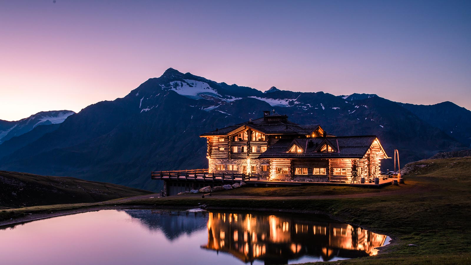 Il mountain lodge durante la notte illuminato dalle luci presso il parco naturale dello Stelvio